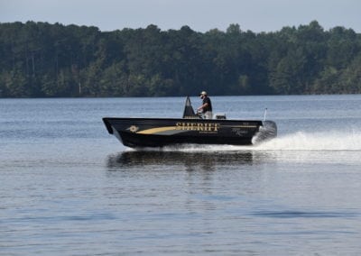 man driving a sheriffs boat side angle